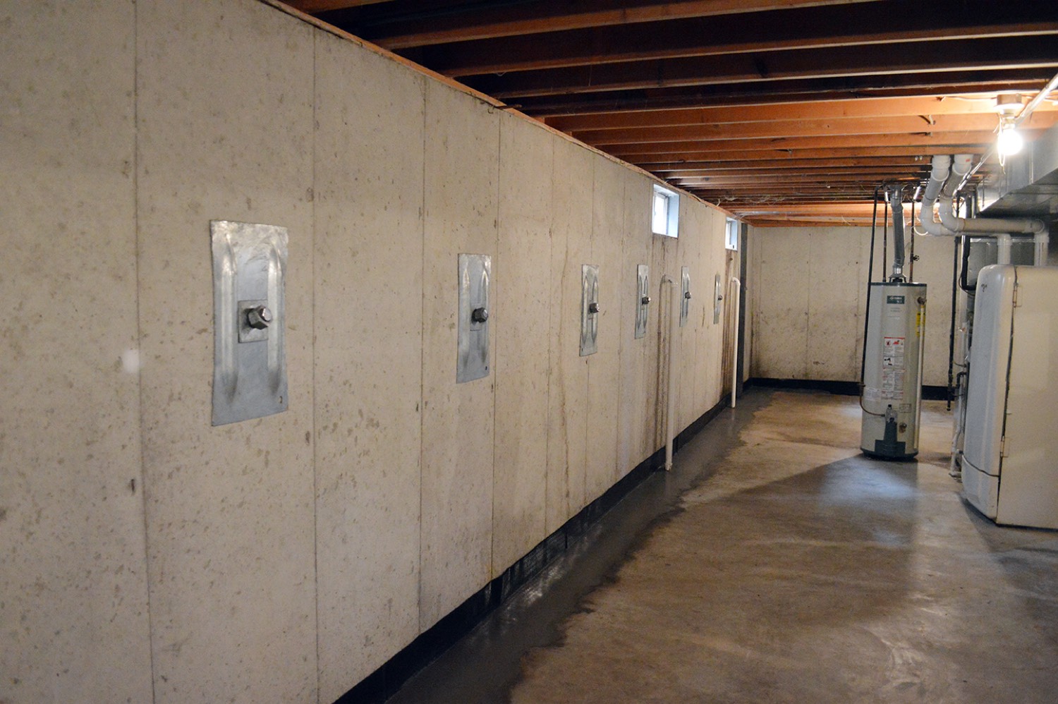 Wall anchor plates on a poured basement wall